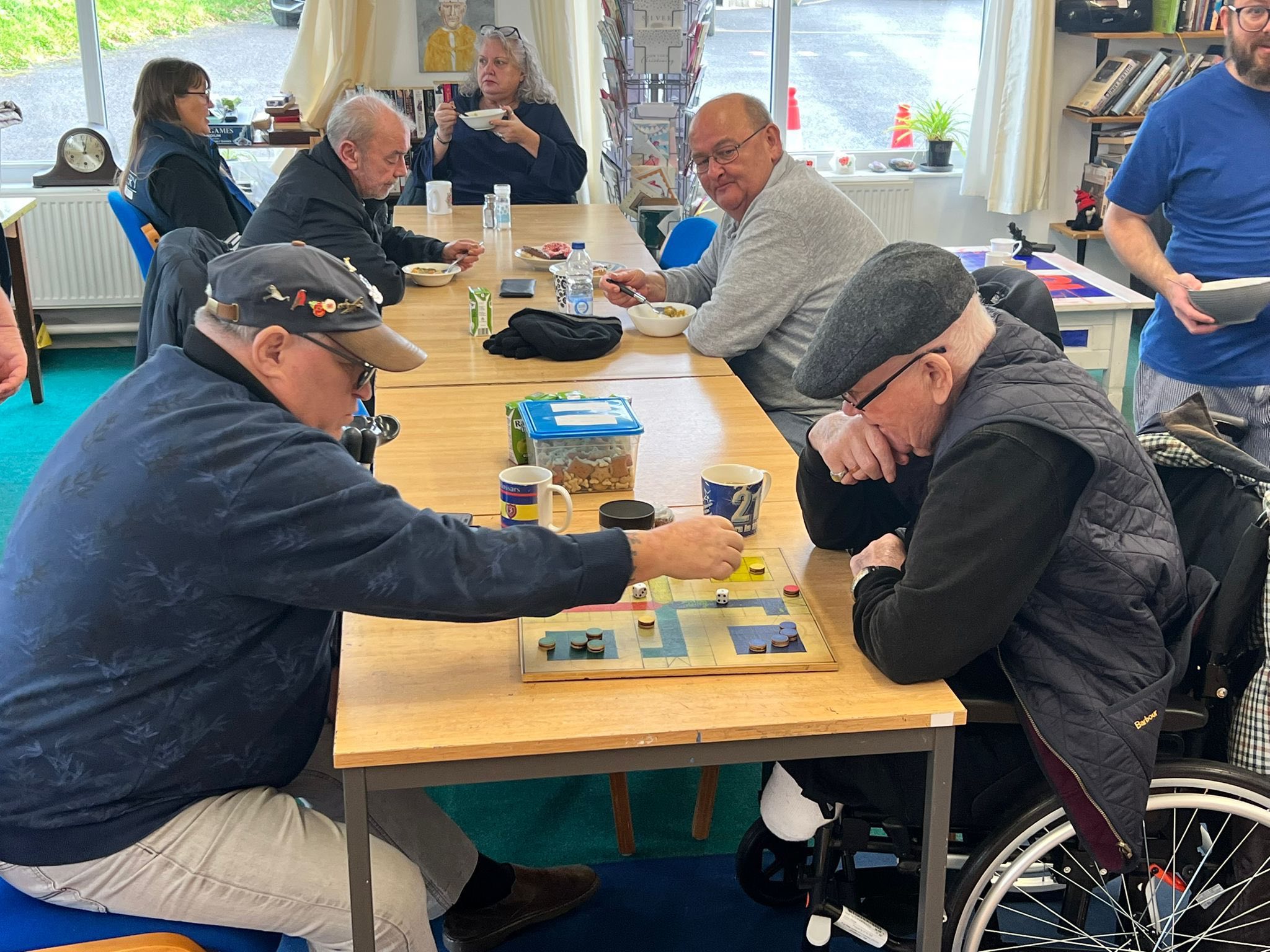 Photograph of group of veterans and volunteers enjoying a cup of tea in the VC Gallery cafe area